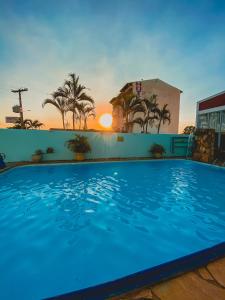 una gran piscina con puesta de sol en el fondo en Manhattan Hotel, en Caldas Novas