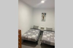 1 dormitorio con 2 camas y mesa en CAL PINTABOTES - Apartamento nuevo en Camarasa, en Camarasa