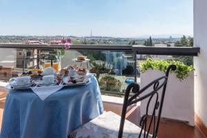 a table with a blue table cloth on a balcony at Hotel Pineta Palace in Rome +40 photos