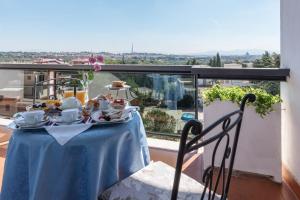 ローマにあるホテル ピネータ パレスのバルコニーに青いテーブルクロス付きのテーブル