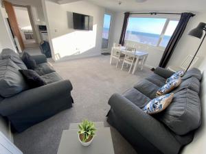 uma sala de estar com 2 sofás e uma sala de jantar com uma mesa em Bridlington Bay Apartments em Bridlington