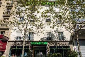 um edifício com um sinal verde em frente em HOTEL DE PARIS MONTPARNASSE em Paris