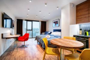 a hotel room with a bed and a table and chairs at EASY RENT- Aperta ART Centrum, Basen & SPA, Free Parking 24h Check-in in Lublin