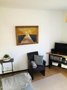 uma sala de estar com uma cadeira e uma fotografia na parede em Haus Johannes em Deudesfeld