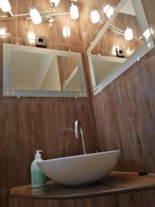 La salle de bains est pourvue d'un lavabo blanc et d'un miroir. dans l'établissement Kámán Nyaraló, à Bytom