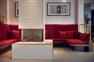 ein Wohnzimmer mit roten Sofas und einem Kamin in der Unterkunft Kimpton De Witt Amsterdam, an IHG Hotel in Amsterdam