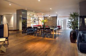 uma sala de jantar e sala de estar com mesa e cadeiras em Kimpton De Witt Amsterdam, an IHG Hotel em Amsterdã
