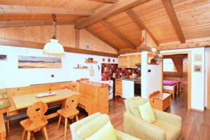 - une cuisine avec une table et des chaises en bois dans l'établissement Aurturist Dobbiaco Roulette, à Dobbiaco