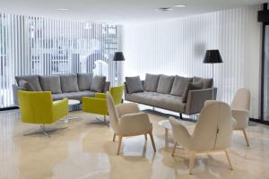 a living room filled with furniture and a large window at NH Ciudad de Santander in Santander