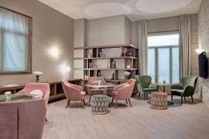 a living room with chairs and a table and a couch at NH Collection León Plaza Mayor in León