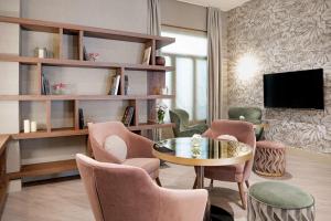 a living room with a table and chairs and a tv at NH Collection León Plaza Mayor in León