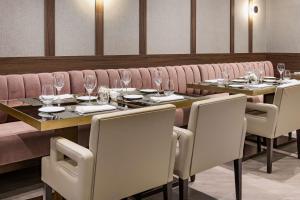 a dining room with tables and chairs with wine glasses at NH Collection León Plaza Mayor in León