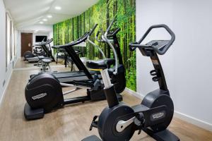 a gym with several tread machines in a room at NH Collection León Plaza Mayor in León