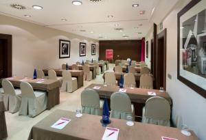 a conference room with tables and chairs in it at NH Collection León Plaza Mayor in León