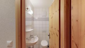 un bagno con un water bianco e un lavandino di Pracondu OUTDOOR & FUN appartement 1 chambre avec balcon by Alpvision Résidences a Nendaz