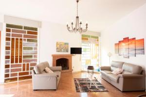 a living room with two couches and a fireplace at Villa Faro a pochi passi dalla spiaggia in San Vito lo Capo