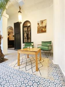ein Wohnzimmer mit einem Tisch und einem Sofa in der Unterkunft Riad Fabiola Et Spa in Marrakesch