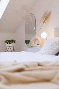 Dormitorio blanco con cama y lámpara en New luxury main square apartment, en Brno