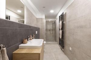 bagno con lavandino bianco e doccia di New luxury main square apartment a Brno