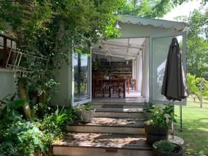 - une vue sur l'extérieur d'une maison avec un parasol dans l'établissement Cranberry Cottage, à Ladybrand