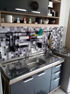 a kitchen with a sink and a tiled wall at Minha Praia in Rio de Janeiro