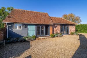 a brick house with a blue door and windows at Romantic cottage in pretty village with great pubs - Stoke Cartlodge in Colchester