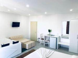uma sala de estar branca com uma cama e uma mesa em Hotel Lakaj em Velipojë