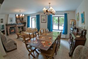ein Esszimmer mit einem Tisch, Stühlen und einem Kamin in der Unterkunft Holiday Home Le Pihon in Gouvy