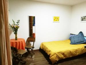 a bedroom with a bed and a table with a vase on it at Casa artistica CANDELARIA in Bogotá