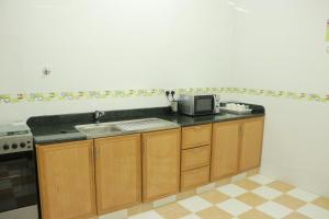 a kitchen with a sink and a microwave at Al Nile Hotel in Salalah