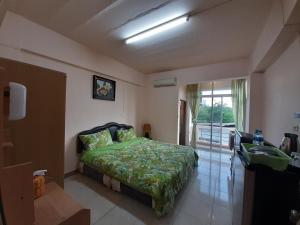 ein Schlafzimmer mit einem Bett und ein Badezimmer mit einem Waschbecken in der Unterkunft Vanlisut Hotel Ngamwongwan in Nonthaburi