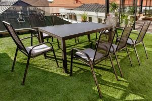 カポシュヴァールにあるLa Pergola & Prestige Panzióの芝生の上に座る椅子とテーブル