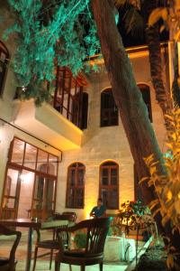 a man sitting at a table in front of a building at Duran Aga Konagi in Şahinbey