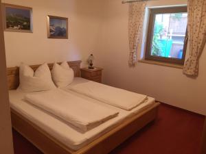 アルプバッハにあるFerienwohnung Marleneのベッドルーム1室(白いシーツ付きのベッド1台、窓付)