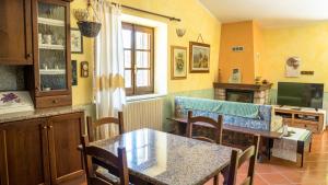 a kitchen with a table and chairs and a television at Casa Asfodeli - Villetta in campagna con piscina in Cuglieri