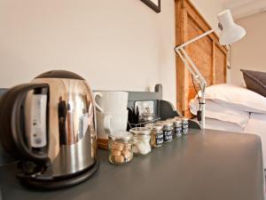 a counter with a coffee maker and jars on a table at Grove Park in Newport