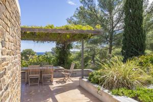 a patio with chairs and a pergola at Bormes les Mimosas in Bormes-les-Mimosas