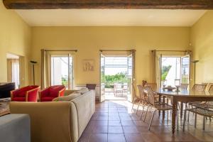 a living room with a couch and a table and chairs at Mouramour in Grimaud