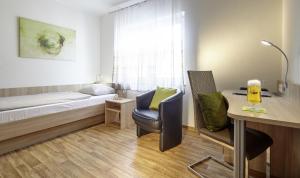een slaapkamer met een bed, een bureau en een stoel bij Hotel zum Stern in Schweich