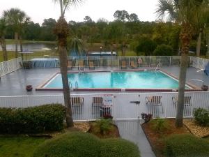 a large swimming pool in a resort with palm trees at Econo Lodge Daytona Beach - Speedway in Daytona Beach
