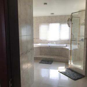 a bathroom with a shower and a bath tub at Alexanders Penthouse on the beach in Ocho Rios