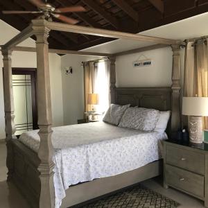 a bedroom with a large bed with a canopy at Alexanders Penthouse on the beach in Ocho Rios