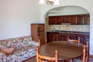 a kitchen with a table and a couch in a room at VILLA ROSA in Duna Verde