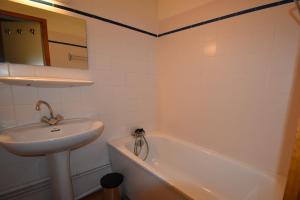 een badkamer met een wastafel, een bad en een wastafel bij VAUJANYLOCATIONS - Cochette 1 Apt 5 in Vaujany