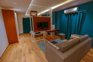 Travelholic Residence New Cairo في القاهرة: غرفة معيشة بها أريكة وتلفزيون