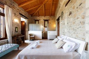 een slaapkamer met een bed en een stenen muur bij Villa Candice in Maroulás