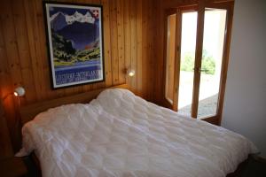 a bedroom with a bed with a poster on the wall at Fontannets 006 MOUNTAIN & QUIET chalet 10 pers in Veysonnaz