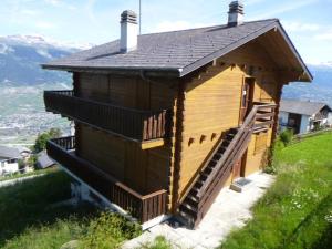 a small wooden house on a hill with a staircase at La Crettaz app dans chalet - SUNNY apartment 6 p in Veysonnaz