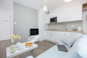 a kitchen and a living room with a table at Apartament City Center Strzelecka by Renters in Poznań