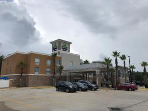 un hotel con coches estacionados en un estacionamiento en Holiday Inn Express & Suites., an IHG Hotel, en Fleming Island